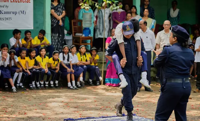 Civil defense members participate in a mock drill to train school students to respond in case of attack in Guwahati, India, Saturday, May 10, 2025 amid rising fears of wider conflict following India's strikes in Pakistan. (AP Photo/Anupam Nath)