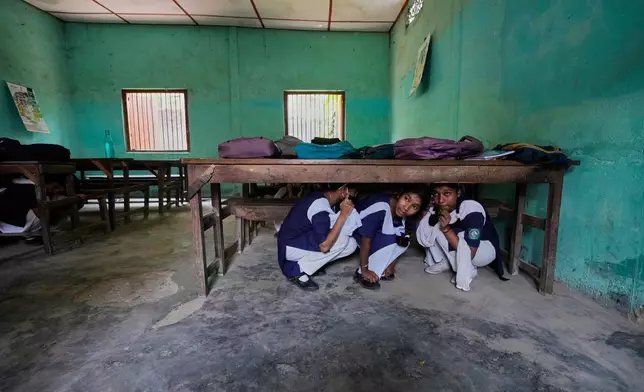 School students participate in a mock drill trained by civil defence members to respond in case of attack in Guwahati, India, Saturday, May 10, 2025 amid rising fears of wider conflict following India's strikes in Pakistan. (AP Photo/Anupam Nath)