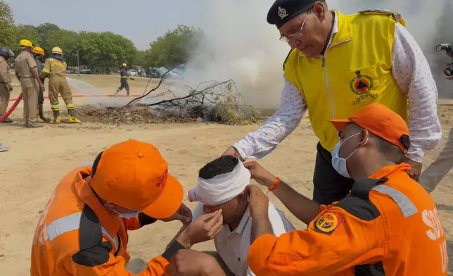 Uttar Pradesh State Disaster Response Force and Civil Defence personnel participate in a mock security drill on the outskirts of Prayagraj, India, Wednesday, May 7, 2025 amid rising fears of wider conflict following India’s strikes in Pakistan. (AP Photo/Rajesh Kumar Singh)