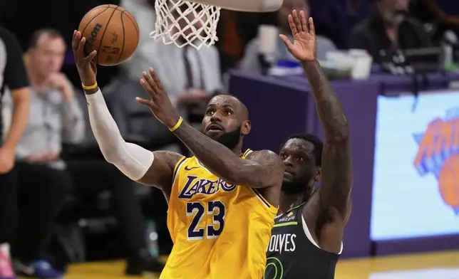 Los Angeles Lakers forward LeBron James, left, shoots as Minnesota Timberwolves guard Donte DiVincenzo defends in the closing seconds in Game 5 of an NBA basketball first-round playoff series Wednesday, April 30, 2025, in Los Angeles. (AP Photo/Mark J. Terrill)
