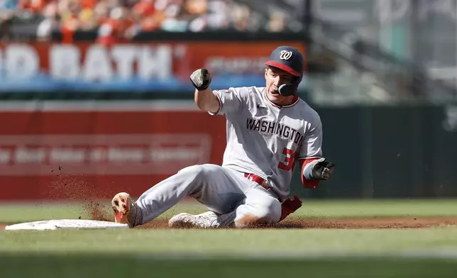 Washington Nationals' Jacob Young slides into third base after hitting a triple off Baltimore Orioles pitcher Kyle Gibson during the first inning of a baseball game in Baltimore, Saturday, May 17, 2025. (AP Photo/Terrance Williams)
