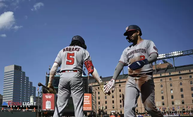 Washington Nationals' CJ Abrams (5) greets Washington Luis García Jr. (2) after Garcia scored on a single hit by Josh Bell off Baltimore Orioles pitcher Kyle Gibson during the first inning of a baseball game in Baltimore, Saturday, May 17, 2025. (AP Photo/Terrance Williams)