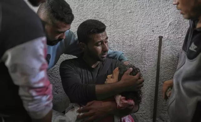 FILE - Anas El Din Hegazy holds the body of his young brother, Zain, 4, who was killed in an Israeli army airstrike on a tent in Gaza City, Monday, April 21, 2025. (AP Photo/Jehad Alshrafi,File)