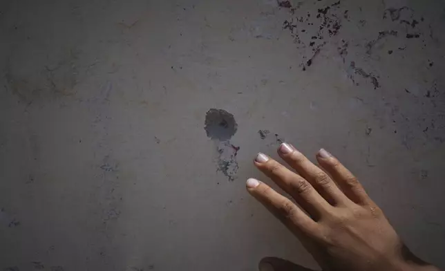 Mohammed Abed shows a mark left by shrapnel on a wall from the day his 4-year-old sister, Massa, was killed by an Israeli army strike in Zawaida, near the city of Deir al-Balah, Gaza Strip, Tuesday April 29, 2025. (AP Photo/Abdel Kareem Hana)