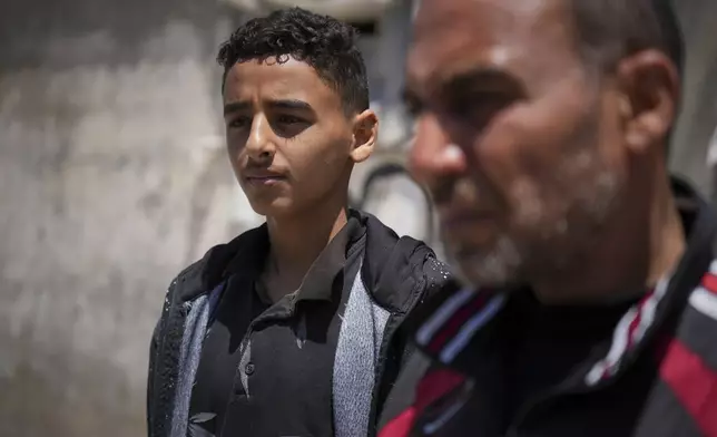 Mohammed Abed, left, stands next to his father, Samy, at the spot where his 4-year-old sister, Massa, was killed by an Israeli army strike in Zawaida, near the city of Deir al-Balah, Gaza Strip, Tuesday, April 29, 2025. (AP Photo/Abdel Kareem Hana)