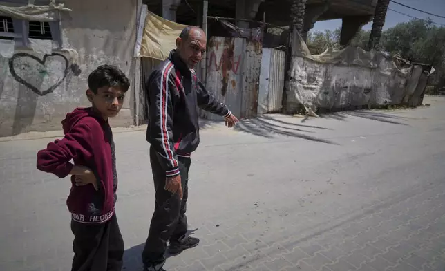 Samy Abed, right, points at the spot where his 4-year-old daughter, Massa, was killed by an Israeli army strike in Zawaida, near the city of Deir al-Balah, Gaza Strip, Tuesday, April 29, 2025. (AP Photo/Abdel Kareem Hana)
