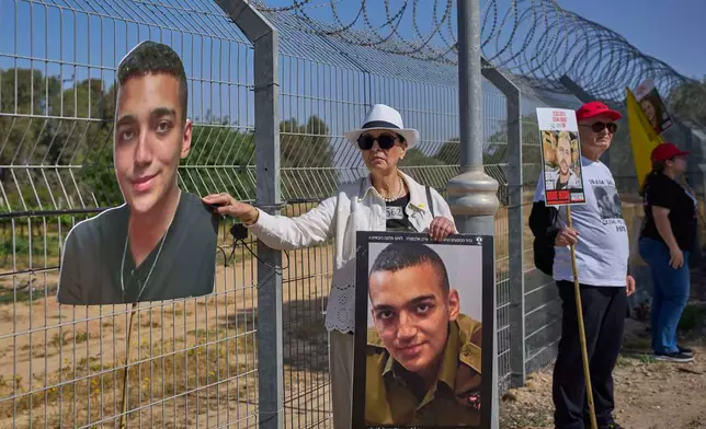 FILE - Varda Ben Baruch holds a picture of her grandson Edan Alexander, who is held hostage in Gaza, gathers with other families to call out on loudspeakers in hopes that their loved ones will hear them, near the Gaza border in Kibbutz Nir Oz, southern Israel, April 20, 2025. (AP Photo/Ohad Zwigenberg, File)
