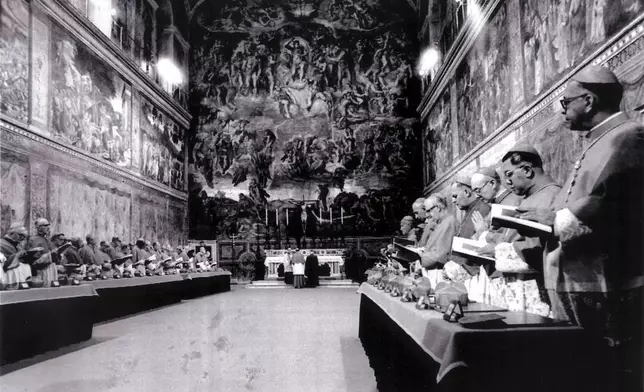FILE - Cardinals stand in prayer inside the Sistine Chapel after they entered the conclave area for electing the successor of late John Paul I. In the background on the wall Michelangelo's famous fresco "The Last Judgement", in this Oct. 14, 1978 file photo. (AP Photo/Pool, File)