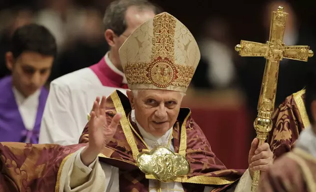 FILE - Pope Benedict XVI blesses the faithful as he arrives at St. Peter's Basilica in the Vatican, Dec. 16, 2010. (AP Photo/Alessandra Tarantino, File)