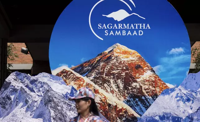 A volunteer awaits to welcome delegates during the inauguration of an environment conference named Sagarmatha Sambaad (Mount Everest Dialogue) at the Soaltee Hotel in Kathmandu, Nepal, Friday, May 16, 2025. (AP Photo/Niranjan Shrestha)estha)