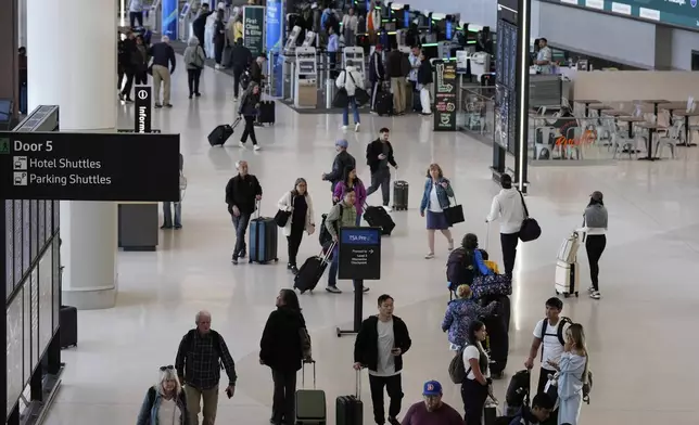 Travelers make their way through Terminal 1 at San Francisco International Airport ahead of the Memorial Day holiday weekend in San Francisco, Thursday, May 22, 2025. (AP Photo/Godofredo A. Vásquez)