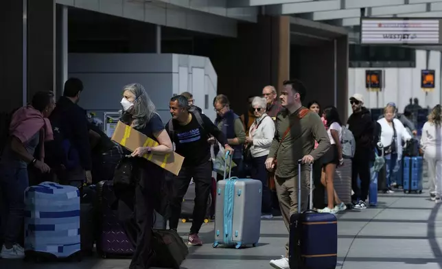 Travelers arrive at San Francisco International Airport ahead of the Memorial Day holiday weekend in San Francisco, Thursday, May 22, 2025. (AP Photo/Godofredo A. Vásquez)
