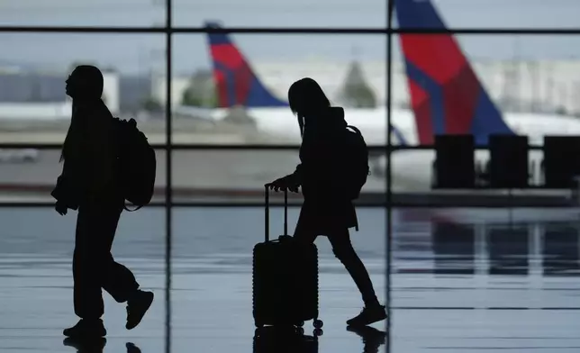 FILE - Travelers walk through Salt Lake City International Airport Friday, May 24, 2024, in Salt Lake City ahead of Memorial Day. (AP Photo/Rick Bowmer, File)