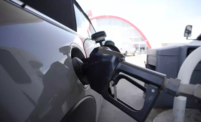 FILE - A motorist fills up their car at a Shell gas station ahead of Memorial Day, Friday, May 26, 2023, in Commerce City, Colo. (AP Photo/David Zalubowski, File)