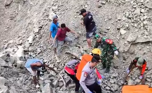 In this handout photo released by the Indonesian National Search and Rescue Agency (BASARNAS), rescuers search for victims at the site of a collapsed natural stones quarry in Cirebon district, West Java province, Indonesia, Friday, May 30, 2025. (BASARNAS via AP)