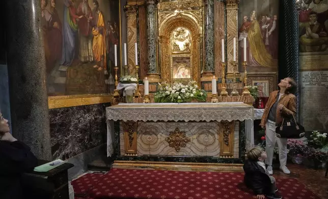 People pray in front of the image of Our Mother of Good Counsel displayed in the Basilica of the Sanctuary in Genazzano, Italy, Thursday, May 15, 2025. (AP Photo/Gregorio Borgia)