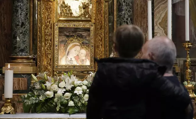 People pray in front of the image of Our Mother of Good Counsel displayed in the Basilica of the Sanctuary in Genazzano, Italy, Thursday, May 15, 2025. (AP Photo/Gregorio Borgia)