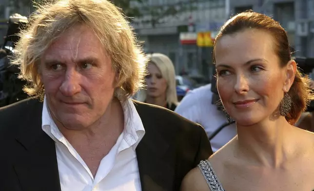 FILE - French actor Gerard Depardieu, left, and French actress Carol Bouquet arrive at the red carpet for the closing ceremony of the 10th Sarajevo Film Festival at the National Theater in Sarajevo, on Aug 28, 2004. (AP Photo/Hidajet Delic, File)