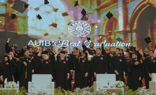 The American University of Iraq - Baghdad graduates throw their mortarboards into the air during the first graduation for the school in Baghdad, Iraq, Saturday, May 24, 2025. (AP Photo/Hadi Mizban)