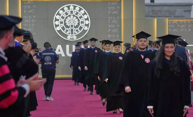 The American University of Iraq - Baghdad students stand together during the first graduation for the school in Baghdad, Iraq, Saturday, May 24, 2025. (AP Photo/Hadi Mizban)