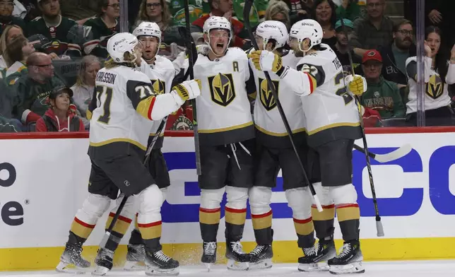 Vegas Golden Knights center Jack Eichel, center, celebrates with teammates after scoring during the second period of Game 6 of a first-round NHL hockey playoff series against the Minnesota Wild, Thursday, May 1, 2025, in St. Paul, Minn. (AP Photo/Bailey Hillesheim)