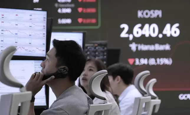 A currency trader talks on the phone near a screen showing the Korea Composite Stock Price Index (KOSPI) at the foreign exchange dealing room of the KEB Hana Bank headquarters in Seoul, South Korea, Tuesday, May 27, 2025. (AP Photo/Ahn Young-joon)