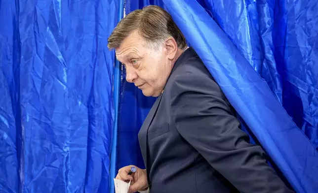 Presidential candidate Crin Antonescu exits a voting booth before casting his vote in the first round of the presidential election redo in Bucharest, Romania, Sunday, May 4, 2025. (AP Photo/Andreea Alexandru)