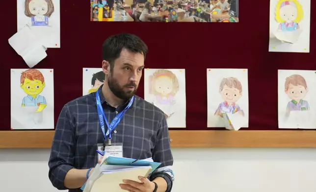 Eoghan Murphy, the head of the OSCE election monitoring delegation takes notes at a polling station during the first round of the presidential election redo in Bucharest, Romania, Sunday, May 4, 2025. (AP Photo/Vadim Ghirda)
