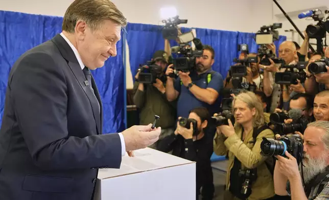 Presidential candidate Crin Antonescu returns the stamp he used for voting in the first round of the presidential election redo in Bucharest, Romania, Sunday, May 4, 2025. (AP Photo/Vadim Ghirda)