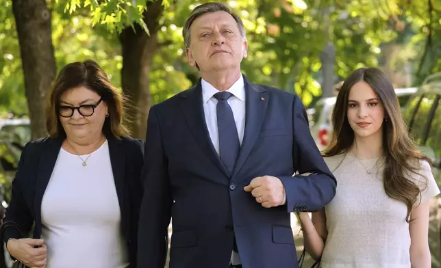 Presidential candidate Crin Antonescu walks with his wife, Adina Valean and daughter Irina, right, after voting in the first round of the presidential election redo in Bucharest, Romania, Sunday, May 4, 2025. (AP Photo/Vadim Ghirda)
