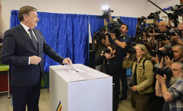 Presidential candidate Crin Antonescu smiles to media as he casts his vote in the first round of the presidential election redo in Bucharest, Romania, Sunday, May 4, 2025. (AP Photo/Vadim Ghirda)