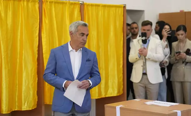 Calin Georgescu, winner of the first round of last year's annulled election, exits a voting booth before casting his vote in the first round of the presidential election redo in Bucharest, Romania, Sunday, May 4, 2025. (AP Photo/Vadim Ghirda)