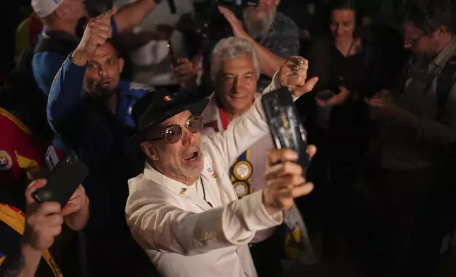 Supporters of Presidential candidate George Simion react to the exit poll results during the first round of the country's presidential election redo in Bucharest, Romania, Sunday, May 4, 2025. (AP Photo/Andreea Alexandru)