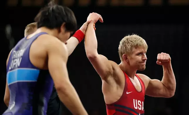 FILE - United States' Kyle Dake, right, celebrates after defeating Japan's Sohsuke Takatani, left, in a 79kg match in the Freestyle Wrestling World Cup in Iowa City, Iowa, April 7, 2018. (AP Photo/Charlie Neibergall, File)
