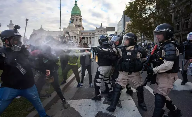 Prefectural police officers fire tear gas at protestors during a weekly demonstration demanding better pensions for retirees, in Buenos Aires, Argentina, Wednesday, May 21, 2025. (AP Photo/Rodrigo Abd)
