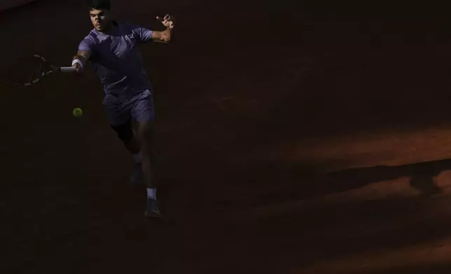 Carlos Alcaraz of Spain, returns to Jannik Sinner of Italy during their final tennis match in the Italian Open at the Foro Italico in Rome, Sunday, May 18, 2025. (AP Photo/Andrew Medichini)