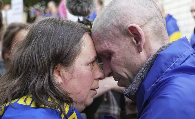 A Ukrainian serviceman Alexander, 45, hugs his wife Elena, 39, after returning from captivity during a POWs exchange between Russia and Ukraine, in Chernyhiv region, Ukraine, Friday, May 23, 2025. (AP Photo/Efrem Lukatsky)