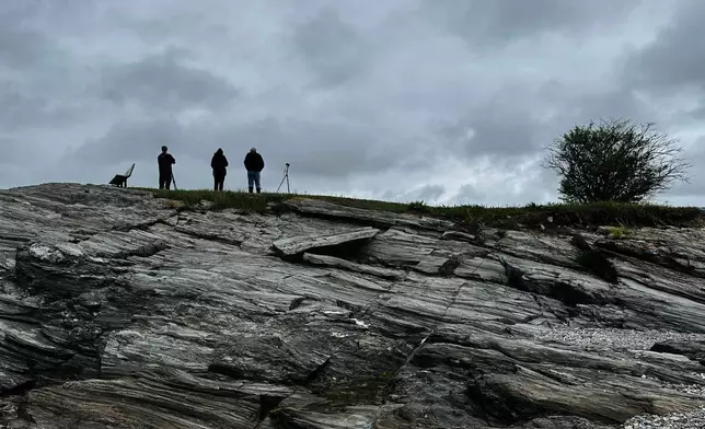 Bird watchers look out under dark skies at Kettle Cove State Park, Thursday, May 22, 2025, in Cape Elizabeth, Maine. (AP Photo/Patrick Whittle)