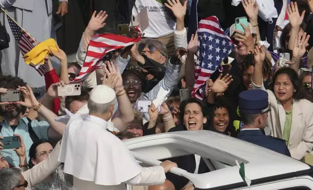 Faithful wave flags of the United States of America as Pope Leo XIV on his popemobile tours St. Peter's Square at the Vatican prior to the inaugural Mass of his pontificate, Sunday, May 18, 2025. (AP Photo/Domenico Stinellis)