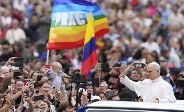 Pope Leo XIV waves as he arrives for his first weekly general audience in St. Peter's Square at The Vatican, Wednesday, May 21, 2025. (AP Photo/Gregorio Borgia)