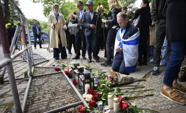 Visitors lay flowers and light candles at a memorial service in front of the Israeli embassy in Berlin, Thursday, May 22, 2025 in memory of the two staff members of the Israeli Embassy who were killed in Washington. (Bernd von Jutrczenka/dpa via AP)