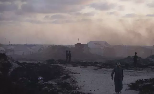 Displaced Palestinians walk through a makeshift tent camp at the Gaza City port on Thursday, May 22, 2025. (AP Photo/Jehad Alshrafi)