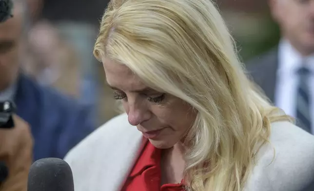 Attorney General Pam Bondi looks down talks with reporters as law enforcement work the scene after two staff members of the Israeli Embassy in Washington were shot and killed outside the Capital Jewish Museum, Thursday, May 22, 2025, in Washington. (AP Photo/Rod Lamkey, Jr.)