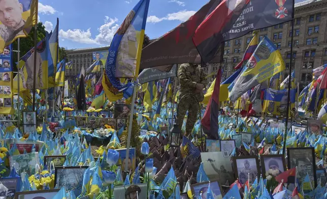 A soldier pays his respect at the memorial to the fallen Ukrainian soldiers on Independence Square in Kyiv, Ukraine, Monday, May 19, 2025. (AP Photo/Efrem Lukatsky)