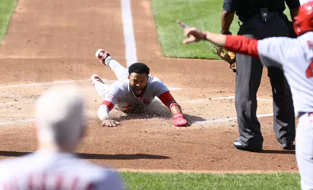 St. Louis Cardinals' Victor Scott II slides home to score on a double by Lars Nootbaar during the second inning of a baseball game against the Washington Nationals, Saturday, May 10, 2025, in Washington. (AP Photo/Nick Wass)