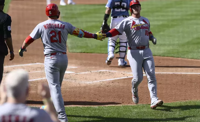 St. Louis Cardinals' Nolan Gorman (16) is greeted by Lars Nootbaar (21) after he scored on a single by Victor Scott II during the second inning of a baseball game against the Washington Nationals, Saturday, May 10, 2025, in Washington. (AP Photo/Nick Wass)