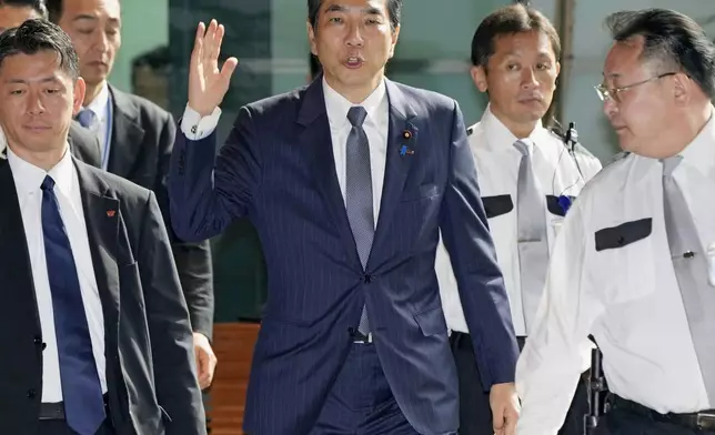 Japan's Agriculture Minister Taku Eto, center, arrives at the prime minister's office in Tokyo Wednesday, May 21, 2025. (Kyodo News via AP)