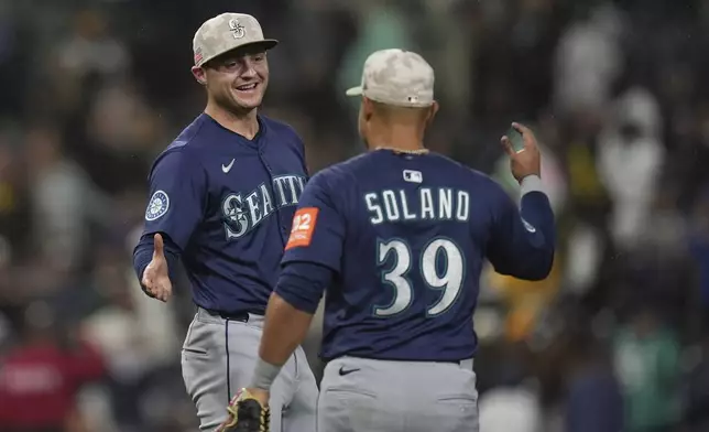 Seattle Mariners third baseman Ben Williamson, left, celebrates with teammate first baseman Donovan Solano after the team defeated the San Diego Padres 4-1 in a baseball game Saturday, May 17, 2025, in San Diego. (AP Photo/Gregory Bull)