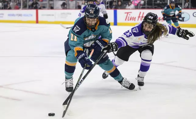FILE - New York forward and Sault Ste. Marie, native Abby Roque, left, and Minnesota defenseman and Plymouth native Mellissa Channell-Watkins battle for the puck during the first period of a PWHL game between the New York Sirens and the Minnesota Frost, at Little Caesars Arena, in Detroit, Sunday, March 16, 2025. (David Guralnick/Detroit News via AP, File)