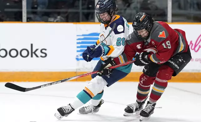 FILE - New York Sirens' Micah Zandee-Hart (28) keeps Ottawa Charge's Brianne Jenner (19) from the puck during first period PWHL hockey action in Ottawa, on Wednesday, Feb. 26, 2025. (Justin Tang/The Canadian Press via AP, File)